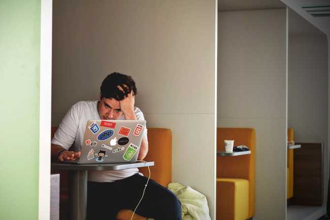 Exhausted manager in white shirt with macbook pro